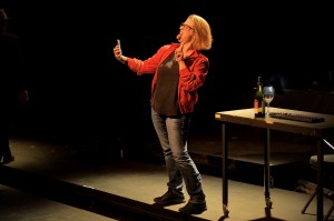 A white woman in a red jacket takes a selfie, sticking out her tongue.